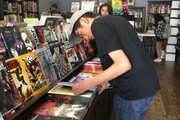 Pre-college student tours a comic book store during Intro to Comics and Graphic Novels course